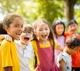 Multi-ethnic group of school children laughing and embracing